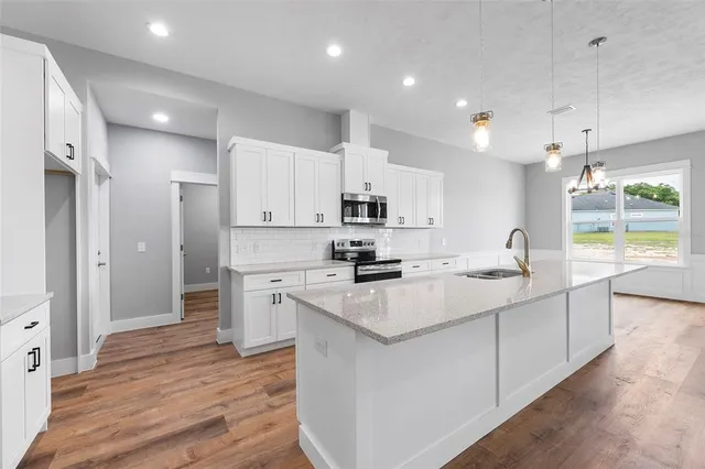 a kitchen with stainless steel appliances granite countertop a sink stove and refrigerator