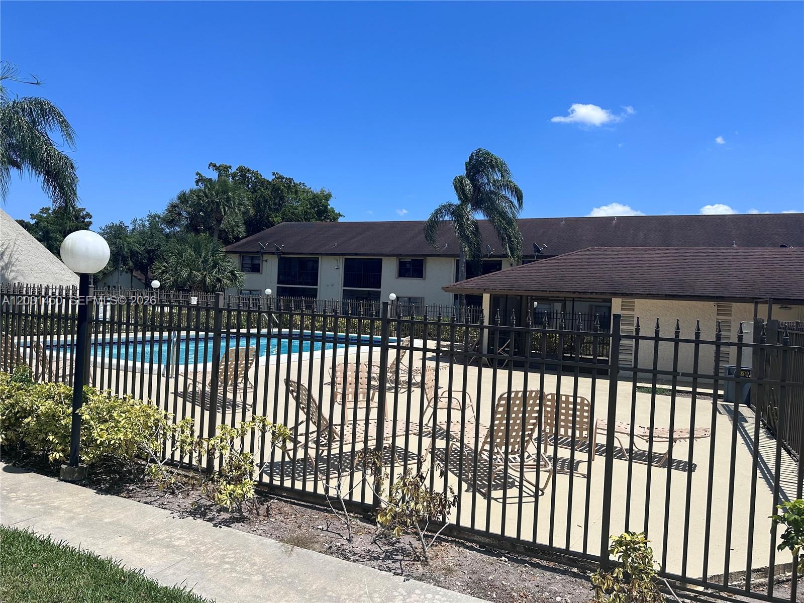 23398 Lyons Road, Unit 309 Boca Raton, FL 33428 - Photo 3 of 16 a front view of a house with a iron fence