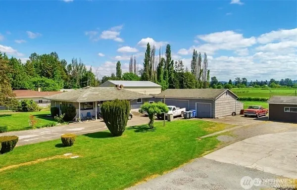 a view of a house with garden and a cars park