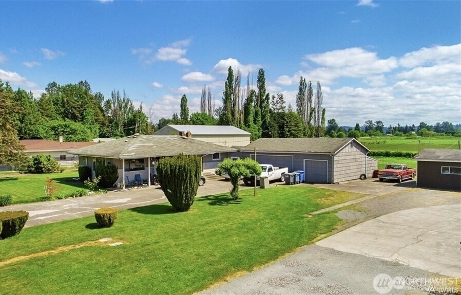 a view of a house with garden and a cars park