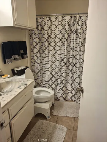 a bedroom with a bed and painting on the wall