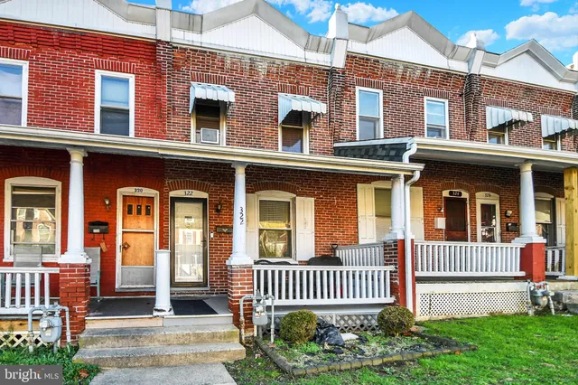 front view of a brick house with a small yard
