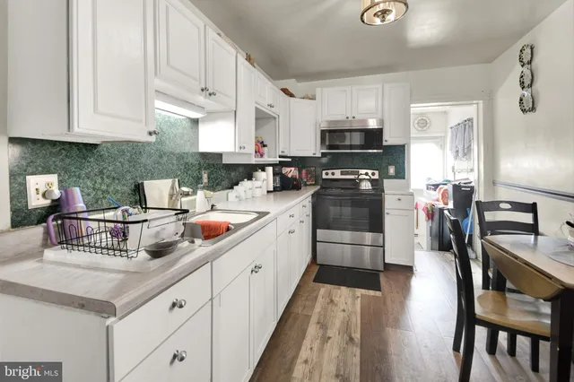 a kitchen with stainless steel appliances a stove a sink a microwave and cabinets