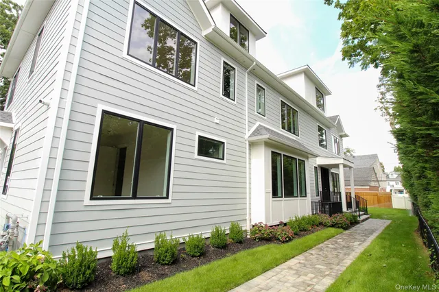 a view of a house with many windows and plants