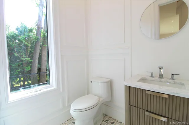 a bathroom with a granite countertop sink mirror and toilet