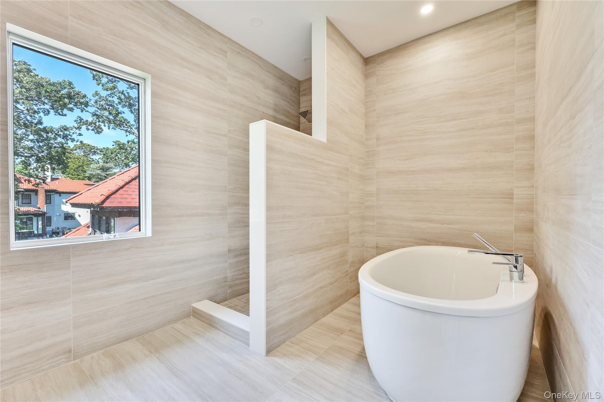 8 Sealy Drive Lawrence, NY 11559 - Photo 24 of 49 Bathroom featuring tile walls, a walk in shower, a freestanding bath, and recessed lighting