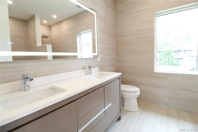 a bathroom with a sink a toilet and a window