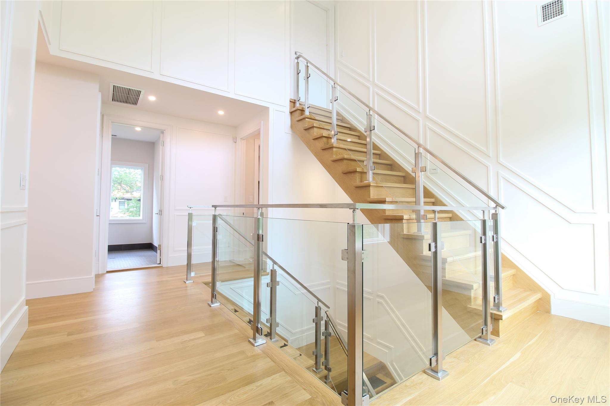 8 Sealy Drive Lawrence, NY 11559 - Photo 31 of 49 Stairs with a decorative wall, wood finished floors, and recessed lighting