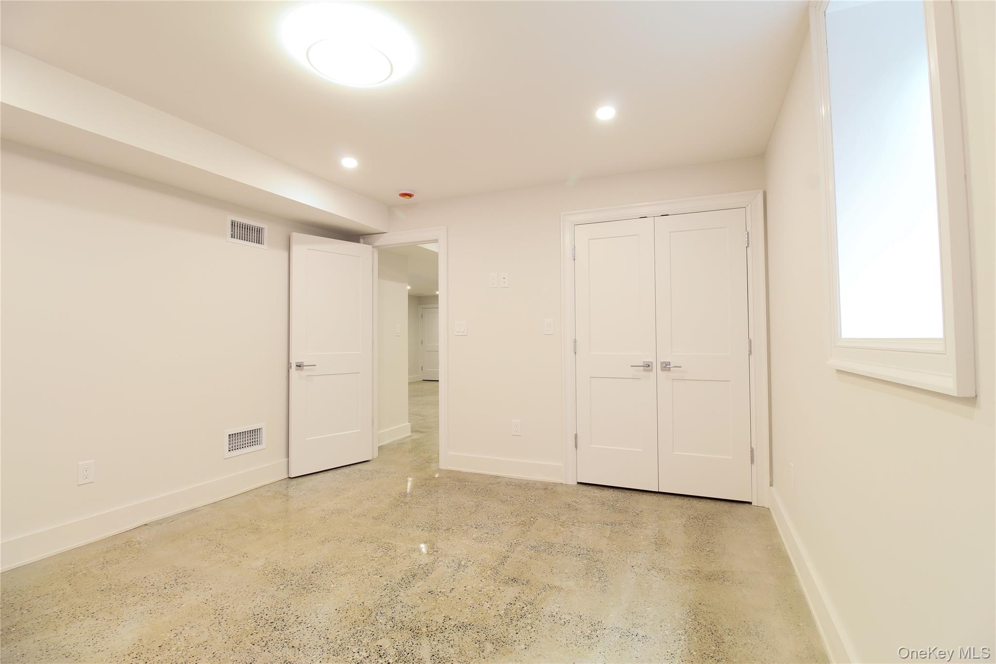 8 Sealy Drive Lawrence, NY 11559 - Photo 36 of 49 Unfurnished bedroom featuring recessed lighting, concrete floors, and a closet