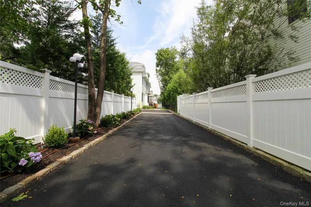 a view of a back yard with an tree and wooden fence