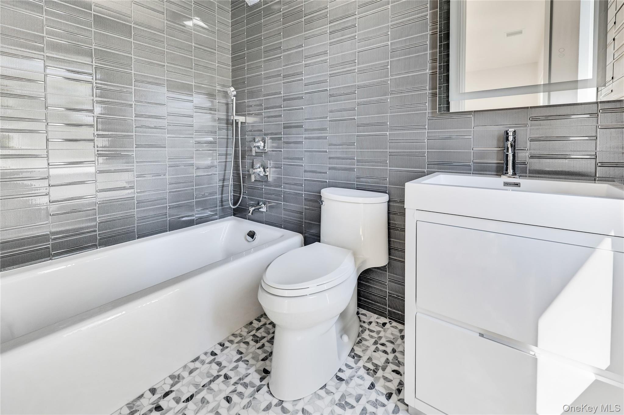 8 Sealy Drive Lawrence, NY 11559 - Photo 48 of 49 Full bath featuring shower / bathtub combination, tile walls, vanity, and light tile patterned flooring