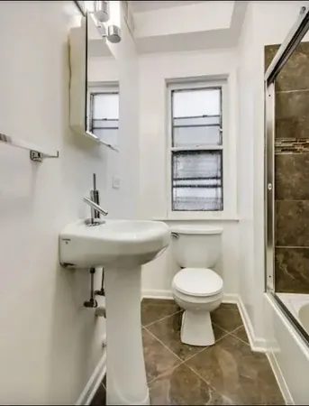 a bathroom with a sink toilet and a mirror