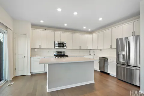 a kitchen with kitchen island a sink stainless steel appliances and cabinets
