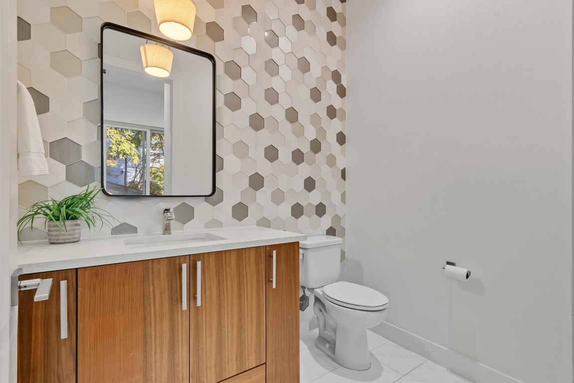 2712 Oak Springs Drive, Unit A Austin, TX 78702 - Photo 14 of 34 a bathroom with a granite countertop sink a toilet and a mirror