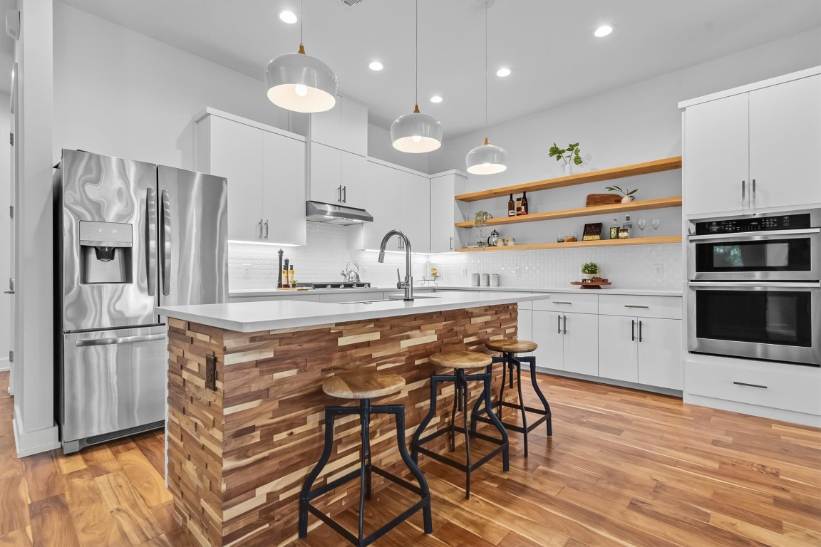 2712 Oak Springs Drive, Unit A Austin, TX 78702 - Photo 2 of 34 a kitchen with stainless steel appliances granite countertop a kitchen island hardwood floor and a sink