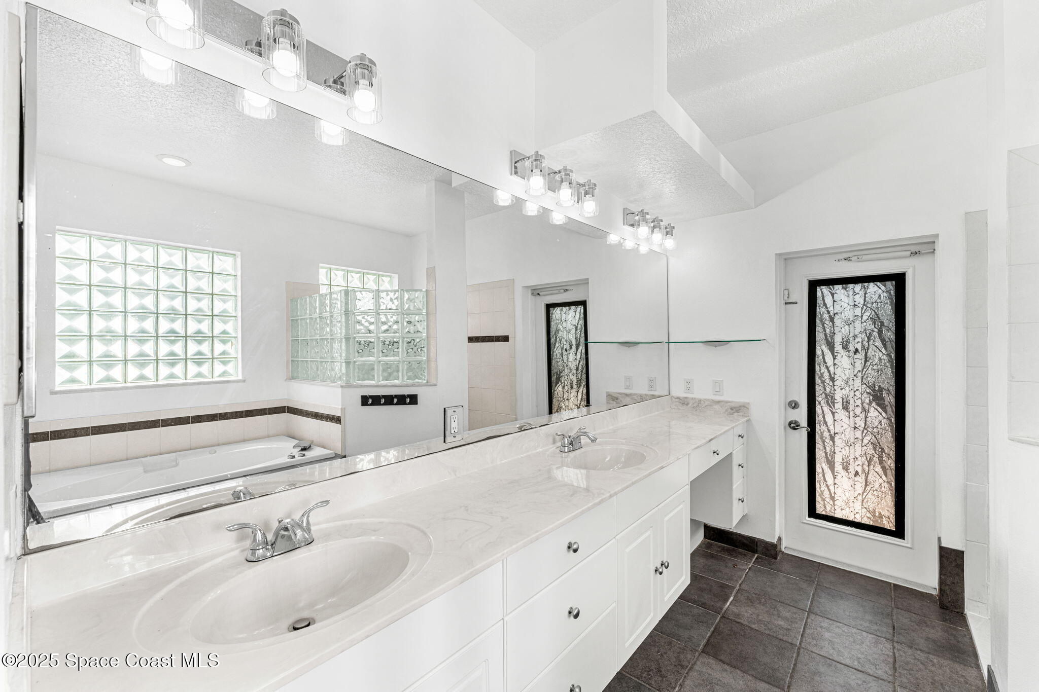 48 Harbor Circle Cocoa Beach, FL 32931 - Photo 26 of 48 a bathroom with a tub a sink double vanity and a mirror