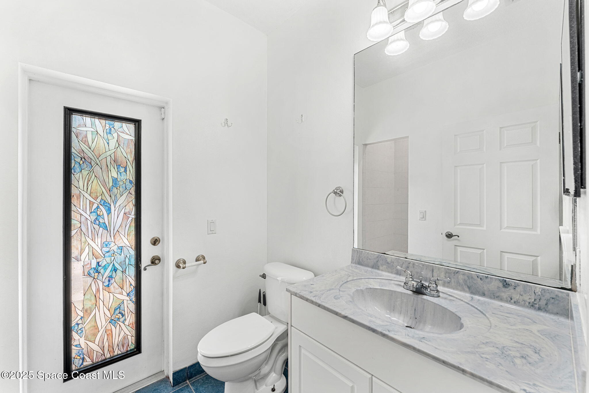 48 Harbor Circle Cocoa Beach, FL 32931 - Photo 30 of 48 a bathroom with a granite countertop sink a toilet a mirror and shower curtain