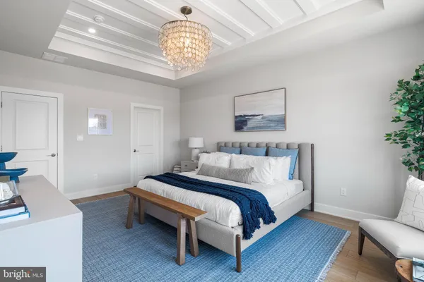 a spacious bedroom with a bed and a chandelier
