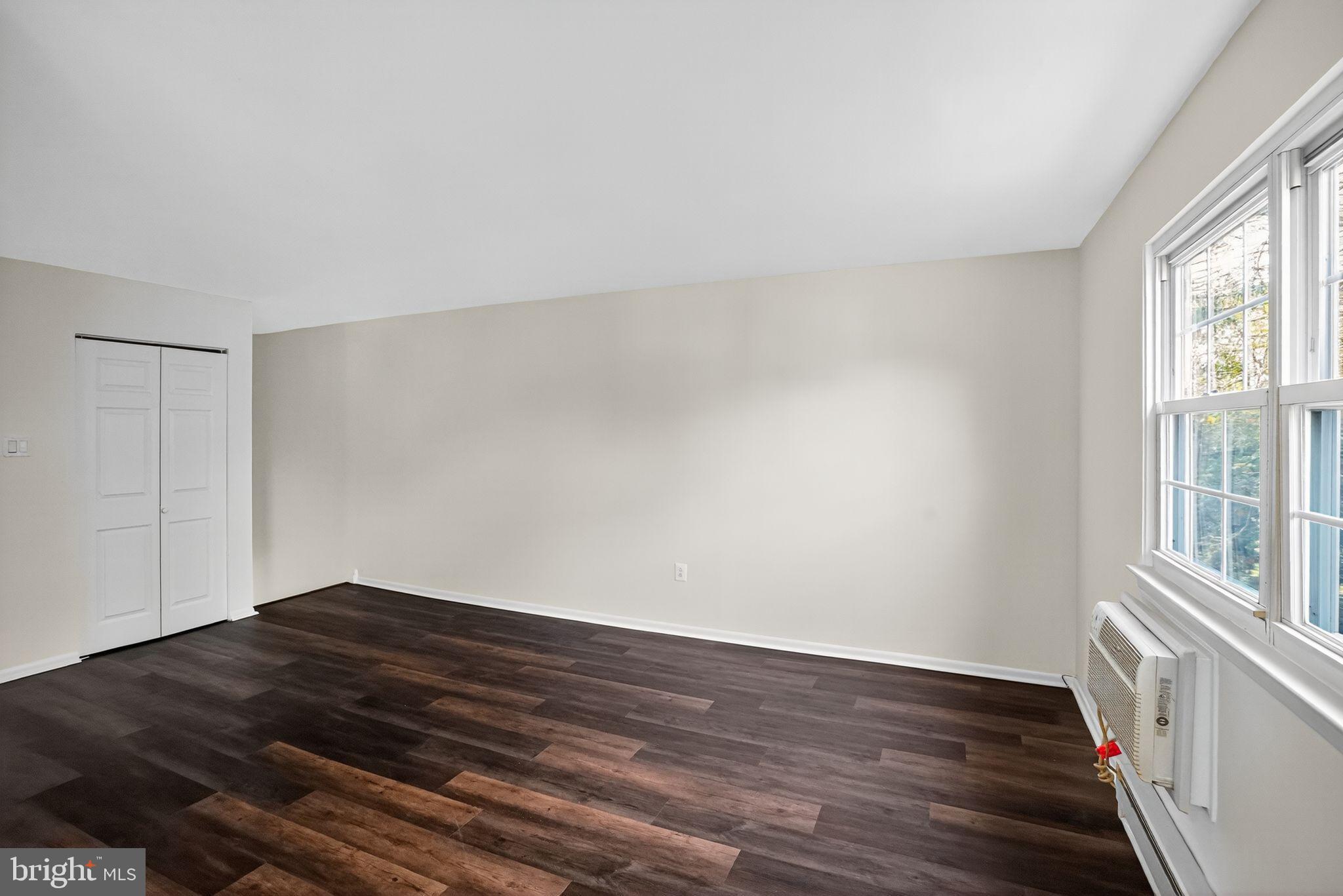 178 Elephant Road, Unit A6 Dublin, PA 18917 - Photo 4 of 17 a view of an empty room with wooden floor and a window