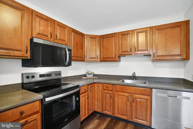 a kitchen with stainless steel appliances granite countertop a stove microwave sink and cabinets