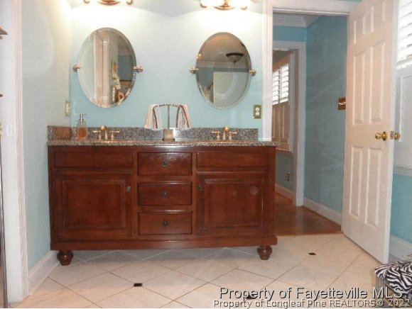 2723 Huntington Road Fayetteville, NC 28303 - Photo 14 of 25 a bathroom with a sink and a mirror