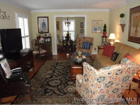2723 Huntington Road Fayetteville, NC 28303 - Photo 3 of 25 a living room with furniture a flat screen tv and a fireplace