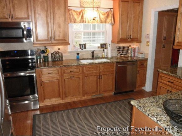 2723 Huntington Road Fayetteville, NC 28303 - Photo 7 of 25 a kitchen with stainless steel appliances granite countertop a stove a sink and a microwave