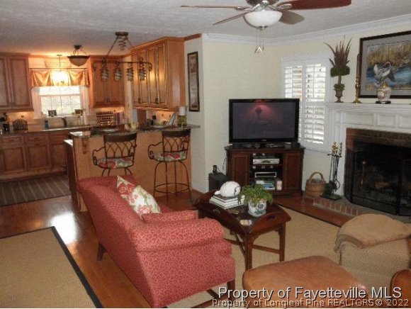2723 Huntington Road Fayetteville, NC 28303 - Photo 10 of 25 a living room with furniture a fireplace and a flat screen tv