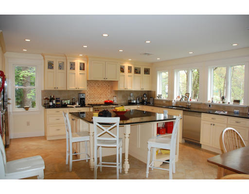 27 Lower Dam Way Dunstable, MA 01827 - Photo 11 of 19 a kitchen with a dining table chairs and white cabinets