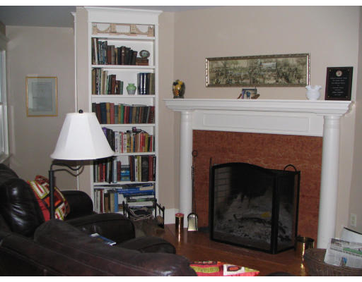 27 Lower Dam Way Dunstable, MA 01827 - Photo 15 of 19 a living room with a fireplace and a book shelf