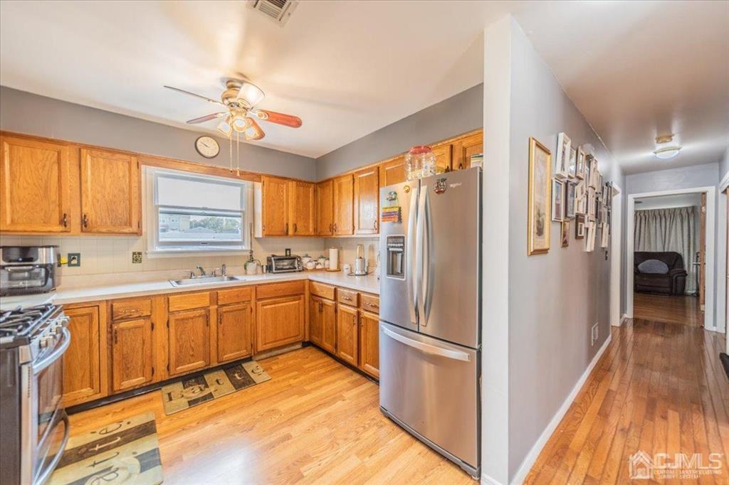 454 Mitchell Place Perth Amboy, NJ 08861 - Photo 11 of 36 a kitchen with stainless steel appliances granite countertop a refrigerator a sink dishwasher a stove and a dining table with wooden floor