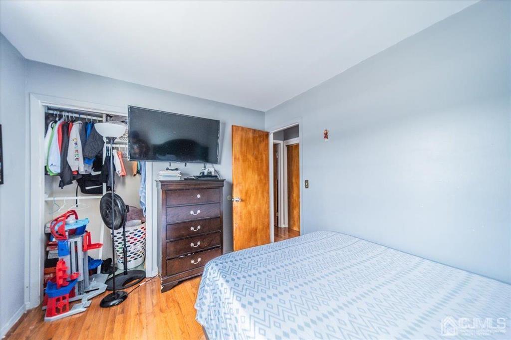 454 Mitchell Place Perth Amboy, NJ 08861 - Photo 15 of 36 a bedroom with a bed and a tv