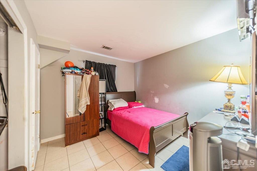 454 Mitchell Place Perth Amboy, NJ 08861 - Photo 22 of 36 a bedroom with a bed and a table