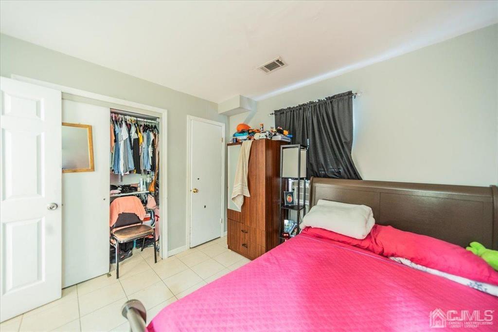 454 Mitchell Place Perth Amboy, NJ 08861 - Photo 23 of 36 a bedroom with a bed and a walk in closet