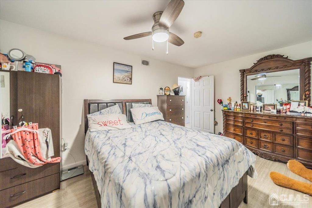 454 Mitchell Place Perth Amboy, NJ 08861 - Photo 29 of 36 a bedroom with a bed and dresser with mirror