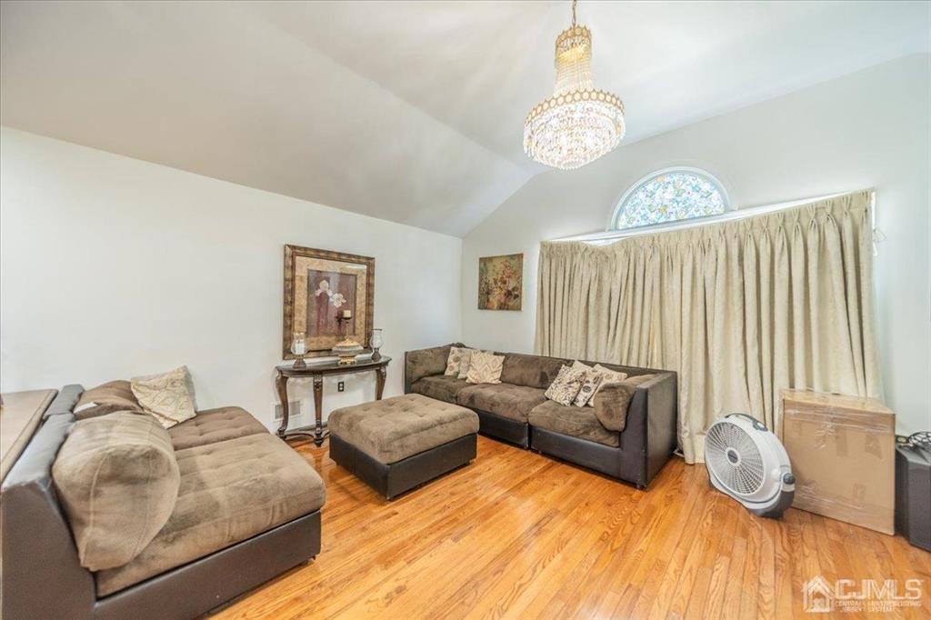 454 Mitchell Place Perth Amboy, NJ 08861 - Photo 4 of 36 a living room with furniture and a chandelier
