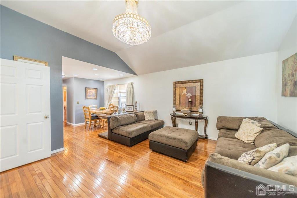 454 Mitchell Place Perth Amboy, NJ 08861 - Photo 5 of 36 a living room with furniture wooden floor and a chandelier