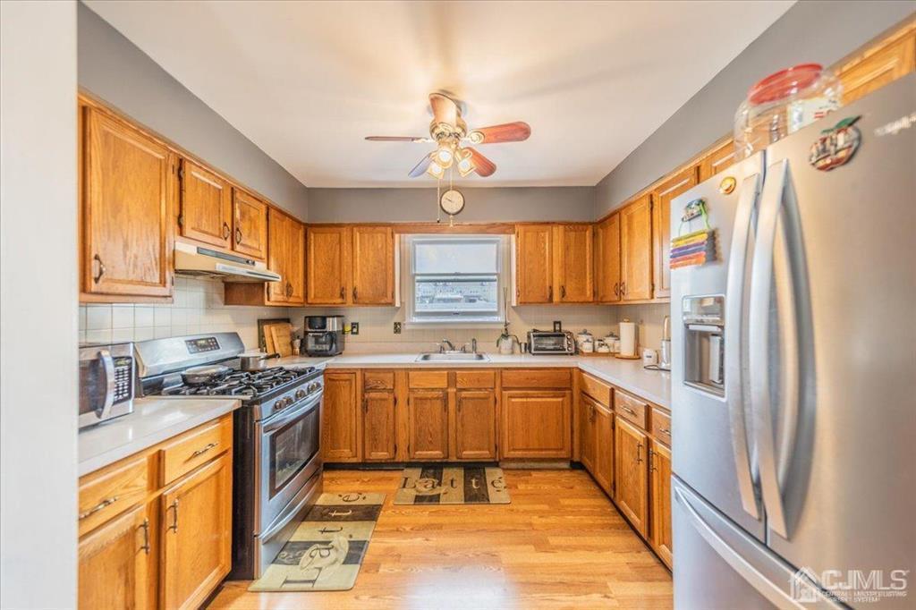 454 Mitchell Place Perth Amboy, NJ 08861 - Photo 7 of 36 a kitchen with stainless steel appliances granite countertop a sink a stove and refrigerator