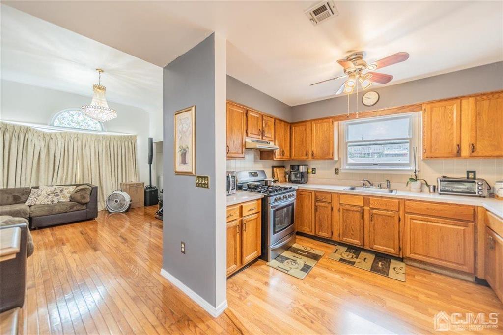454 Mitchell Place Perth Amboy, NJ 08861 - Photo 10 of 36 a kitchen with stainless steel appliances granite countertop a stove a sink dishwasher and a refrigerator with wooden floor