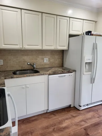 a kitchen with white cabinets and white appliances