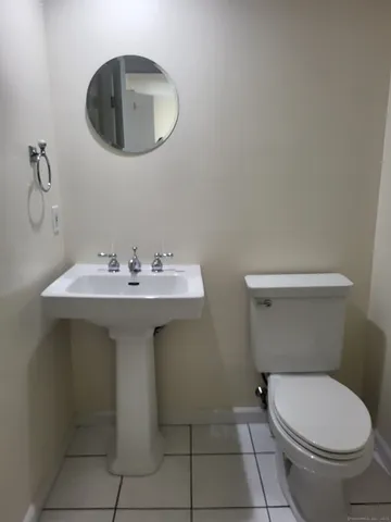 a bathroom with a sink a toilet and a mirror