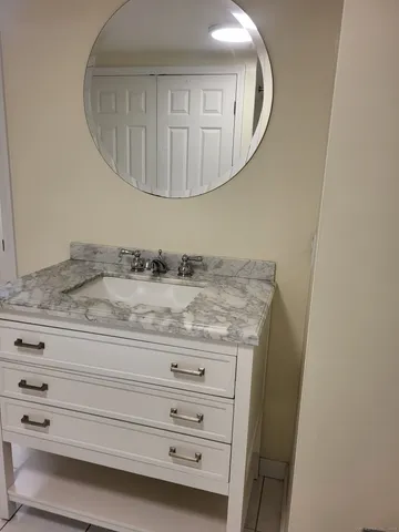 a bathroom with a granite countertop sink a mirror and vanity
