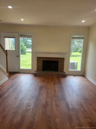 an empty room with windows and fireplace