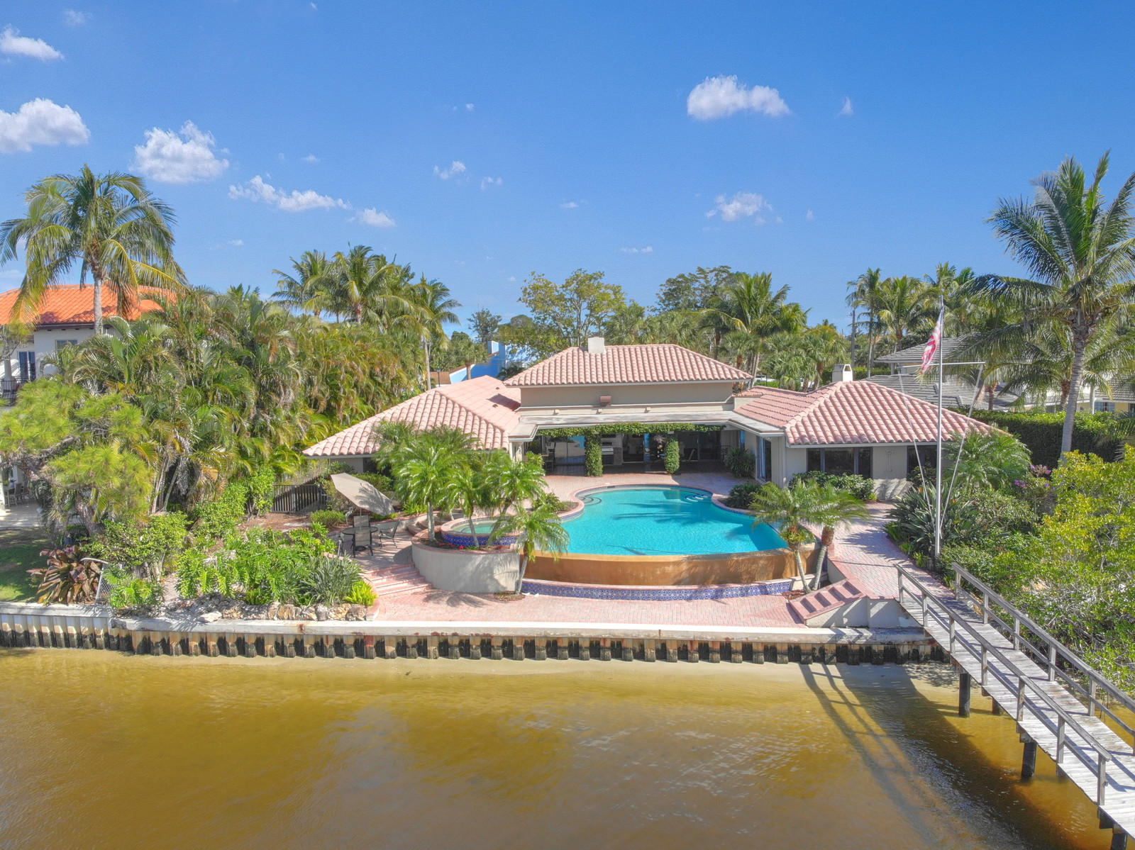 143 Point Circle Tequesta, FL 33469 - Photo 3 of 41 a view of a swimming pool with lawn chairs under an umbrella
