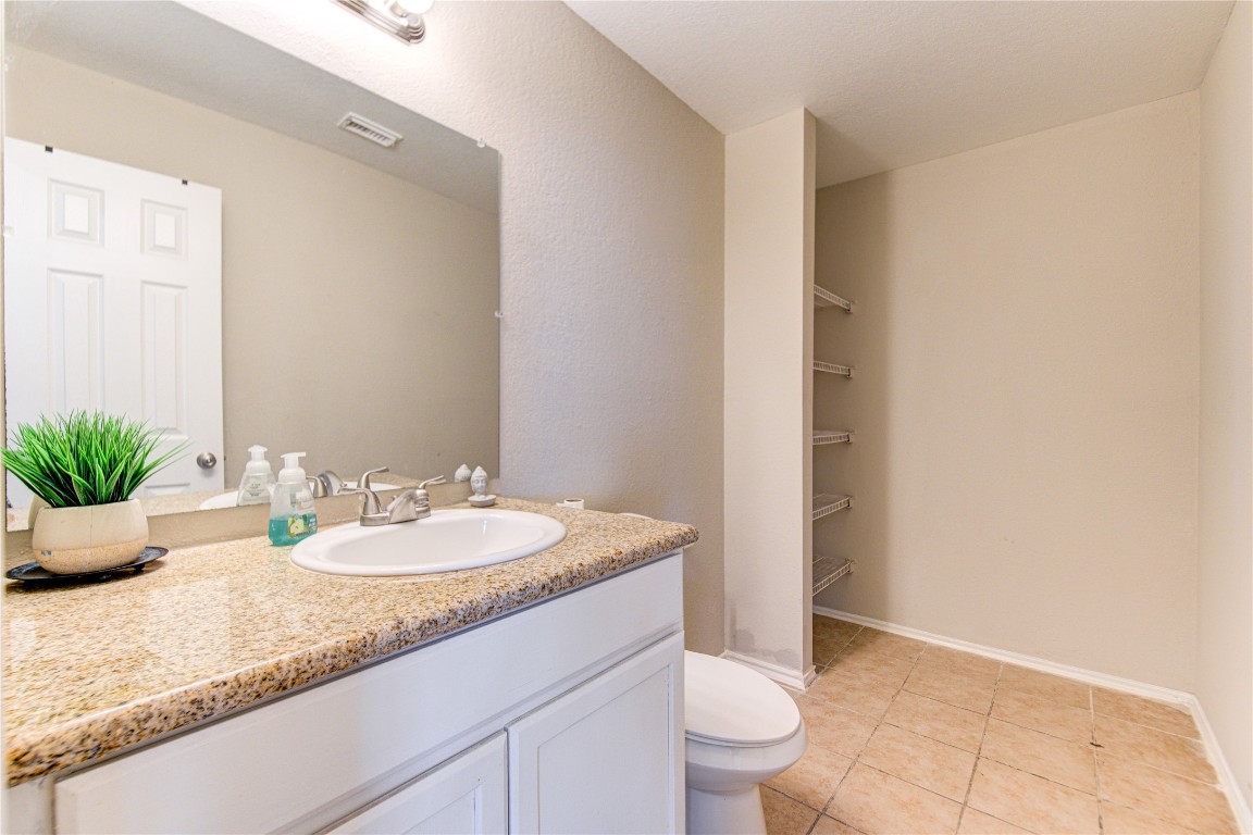 22919 Twisting Maple Court Spring, TX 77373 - Photo 13 of 49 a bathroom with a granite countertop sink a toilet and a mirror