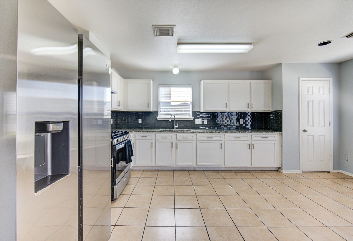 22919 Twisting Maple Court Spring, TX 77373 - Photo 21 of 49 a kitchen with stainless steel appliances granite countertop a stove a sink and a refrigerator