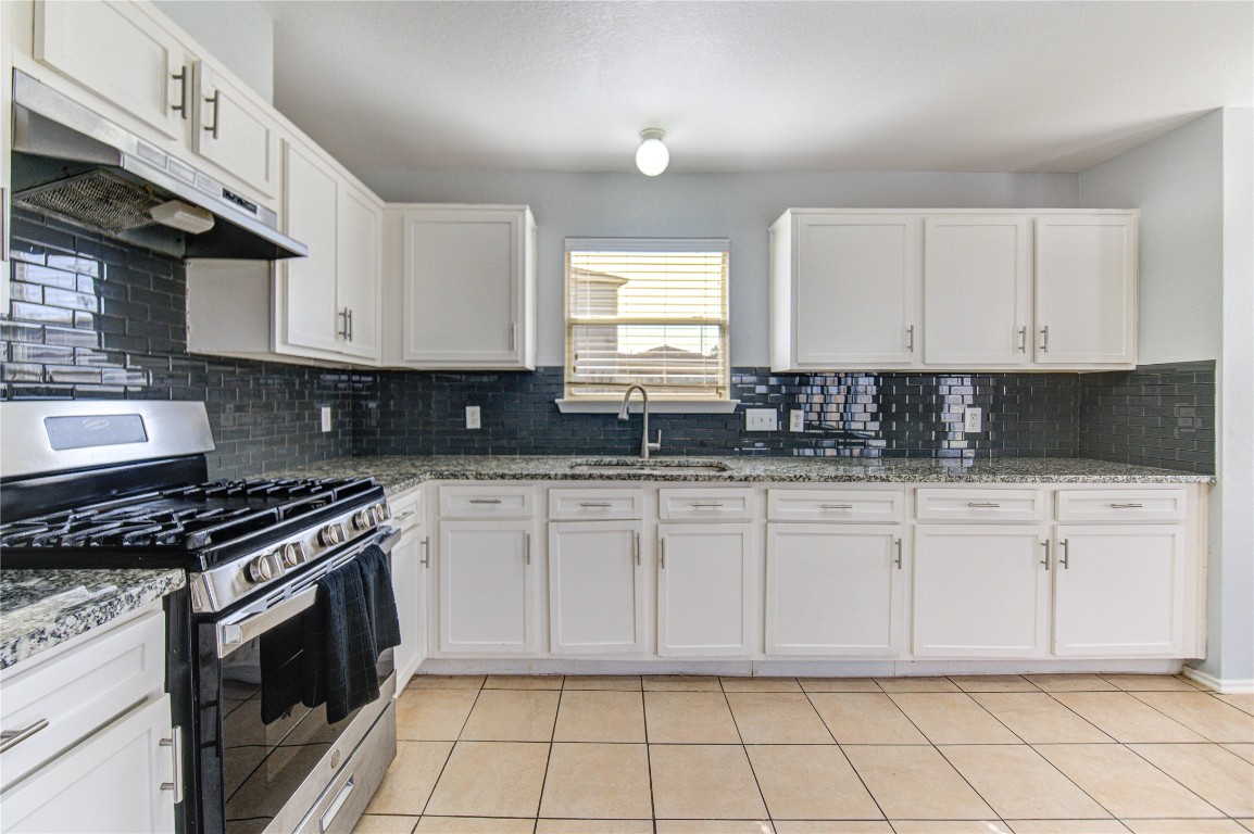22919 Twisting Maple Court Spring, TX 77373 - Photo 22 of 49 a kitchen with granite countertop white cabinets stainless steel appliances and a window