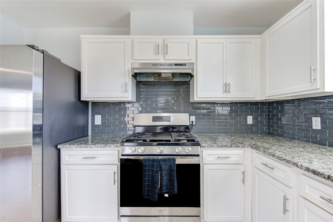 22919 Twisting Maple Court Spring, TX 77373 - Photo 24 of 49 a kitchen with granite countertop white cabinets and stainless steel appliances