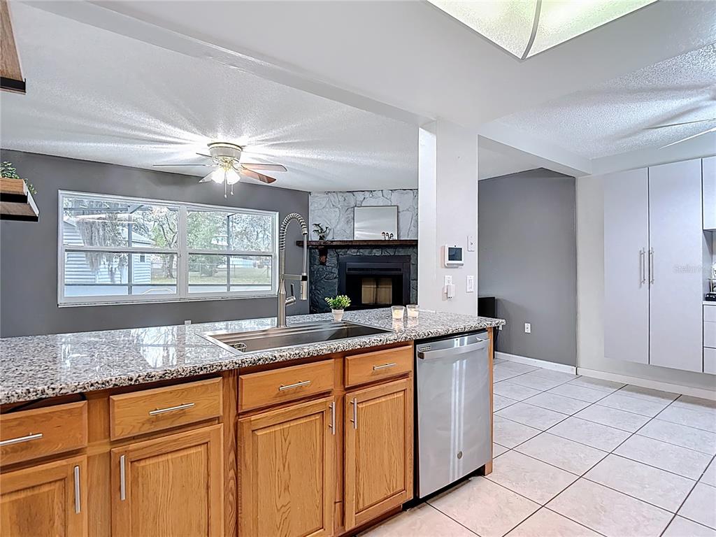 9171 Vicksburg Road Spring Hill, FL 34608 - Photo 11 of 55 a kitchen with granite countertop a sink a stove and cabinets