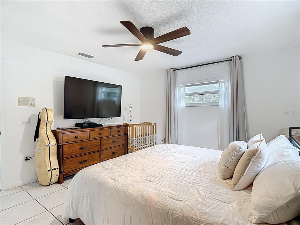 9171 Vicksburg Road Spring Hill, FL 34608 - Photo 18 of 55 a bedroom with a bed and a flat screen tv